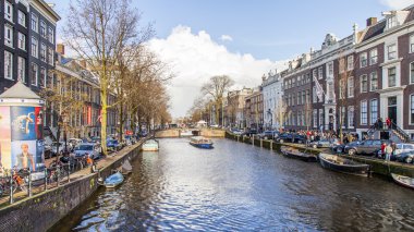 Amsterdam, Hollanda üzerinde 27 Mart 2016. Bahar akşam tipik kent görünümünde. Kanal ve Binalar bentleri tarihinde XVII-XVIII inşaatın Köprüsü