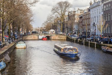 Amsterdam, Hollanda üzerinde 27 Mart 2016. Bahar akşam tipik kent görünümünde. Kanal ve Binalar bentleri tarihinde XVII-XVIII inşaatın Köprüsü
