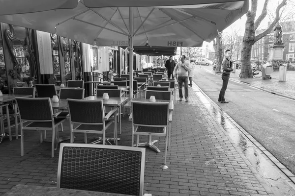 Amsterdam, Hollanda üzerinde 27 Mart 2016. Bahar sabahı tipik kent görünümünde. Açık havada yaz Kafe'nin küçük tablolar. 