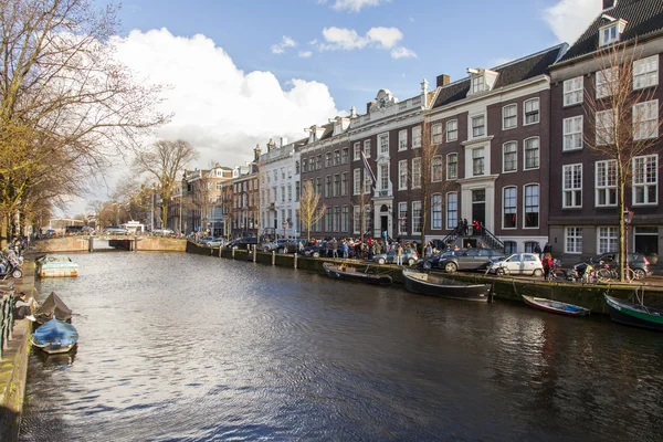 AMSTERDAM, PAÍSES BAJOS el 27 de marzo de 2016. Típica vista urbana en la noche de primavera. El puente a través del canal y los edificios de la construcción XVII-XVIII sobre terraplenes — Foto de Stock