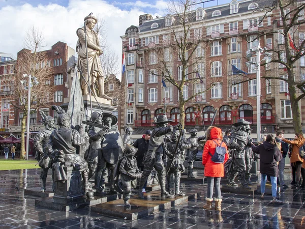 AMSTERDAM, NETHERLANDS on March 27, 2016. Скульптурная композиция Night watch at Rembrandt Square - one of sights of the city. Туристы ходят среди фигур и фотографируются — стоковое фото