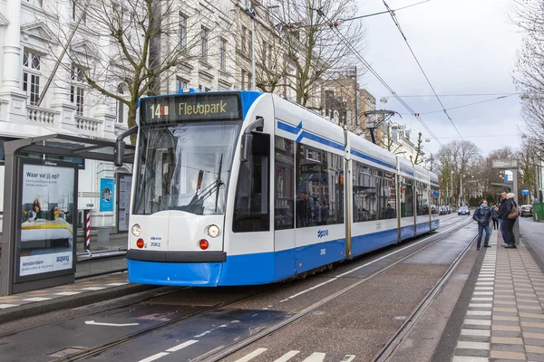 AMSTERDAM, PAESI BASSI il 28 marzo 2016. Tipica vista urbana nel pomeriggio primaverile. Il tram si muove lungo la strada . — Foto Stock
