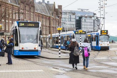 Amsterdam, Hollanda üzerinde 28 Mart 2016. Bahar öğleden sonra tipik kent görünümünde. Tramvay caddeden aşağı taşır. 