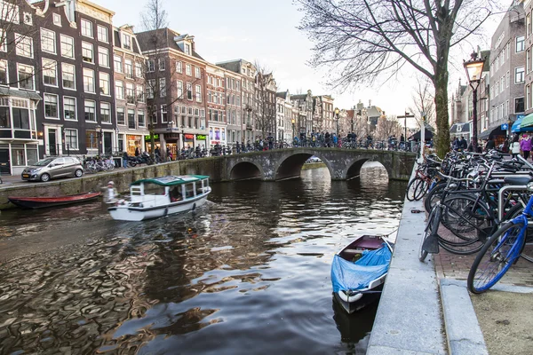 AMSTERDAM, PAYS-BAS, le 27 mars 2016. Vue urbaine typique dans la soirée de printemps. Le pont à travers le canal et les bâtiments de la construction XVII-XVIII sur les remblais — Photo