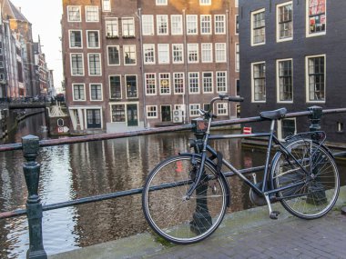 Amsterdam, Hollanda üzerinde 27 Mart 2016. Şehir manzarası. Bisiklet yolu ile kanal köprüde park edilmiş