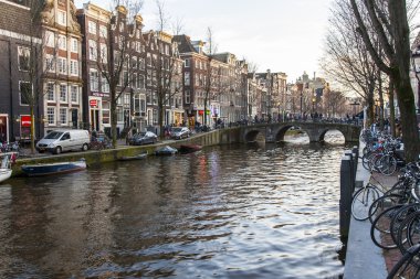 Amsterdam, Hollanda üzerinde 27 Mart 2016. Bahar akşam tipik kent görünümünde. Kanal ve Binalar bentleri tarihinde XVII-XVIII inşaatın Köprüsü