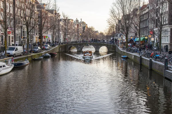 Amsterdam, Nizozemsko na 27 březen 2016. Typický městský pohled v jarní večer. Most přes kanál a budovy stavby Xvii a Xviii na nábřežích — Stock fotografie