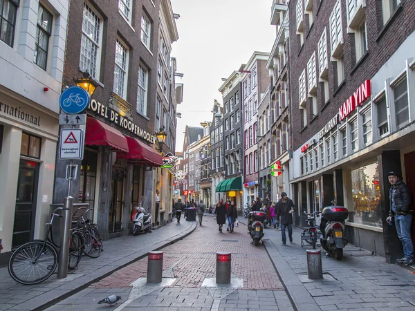 AMSTERDAM, NETHERLANDS on MARCH 27, 2016. Typical urban view in the spring evening. The bridge through the canal and buildings of the XVII-XVIII construction on embankments — Stock Photo, Image