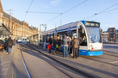 Amsterdam, Hollanda üzerinde 28 Mart 2016. Bahar öğleden sonra tipik kent görünümünde. Tramvay caddeden aşağı taşır. 