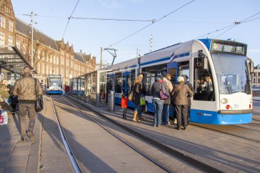 Amsterdam, Hollanda üzerinde 28 Mart 2016. Bahar öğleden sonra tipik kent görünümünde. Tramvay caddeden aşağı taşır. 