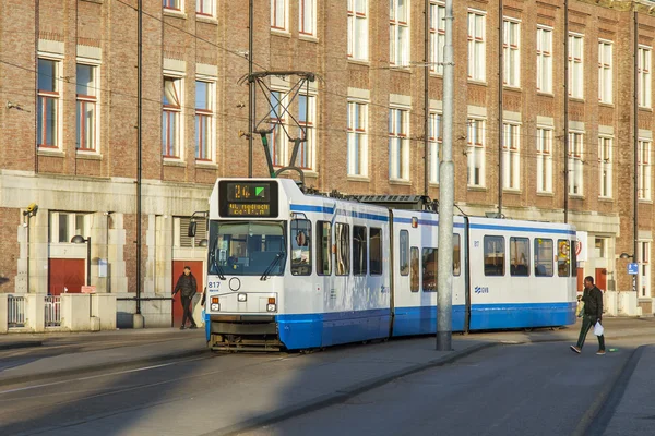 AMSTERDAM, PAESI BASSI il 28 marzo 2016. Tipica vista urbana nel pomeriggio primaverile. Il tram si muove lungo la strada . — Foto Stock