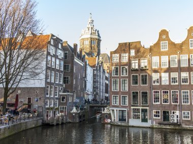 Amsterdam, Hollanda üzerinde 28 Mart 2016. Bahar akşam tipik kent görünümünde. Kanal ve Binalar bentleri tarihinde XVII-XVIII inşaatın Köprüsü