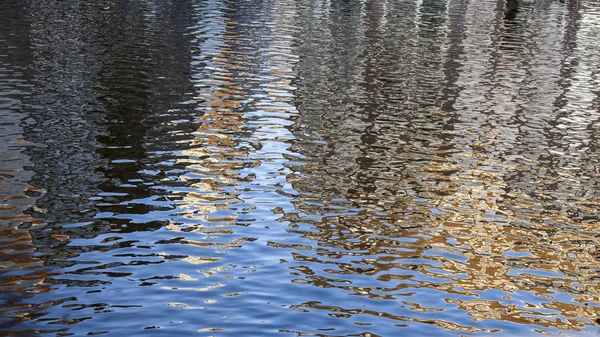 2016 年 3 月 29 日にアムステルダム、オランダ。運河の堤防の建物が水に反映されます。 — ストック写真