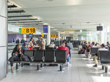 Amsterdam, Hollanda 1 Nisan 2016 üzerinde. Yolcular bir kalkış Amsterdam havaalanında Schiphol bekliyoruz 