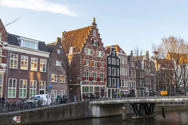 Amsterdam, Nederland op 28 maart 2016. Typisch stedelijke weergave in de lente-avond. De brug door middel van het kanaal en de gebouwen van de bouw van de Xvii-Xviii op taluds — Stockfoto