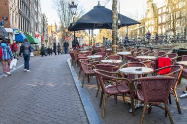Amsterdam, Hollanda üzerinde 28 Mart 2016. Bahar akşam tipik kent görünümünde. Yaz Kafe'nin kaldırımda küçük tablolar.