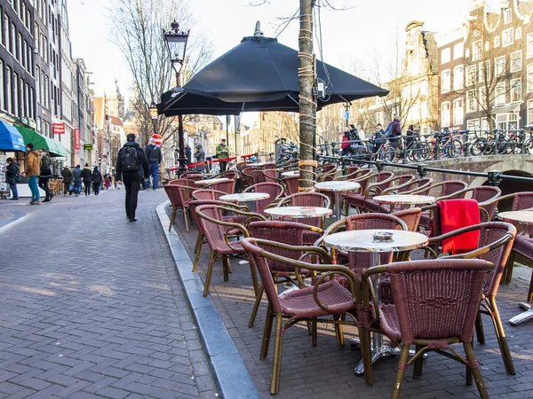 Amsterdam, Nizozemsko na 28 březnu 2016. Typický městský pohled v jarní večer. Malé tabulky letní kavárna na chodníku. — Stock fotografie