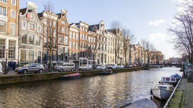 Amsterdam, Hollanda üzerinde 28 Mart 2016. Bahar öğleden sonra tipik kent görünümünde. Kanal ve Binalar bentleri tarihinde XVII-XVIII İnşaat. 