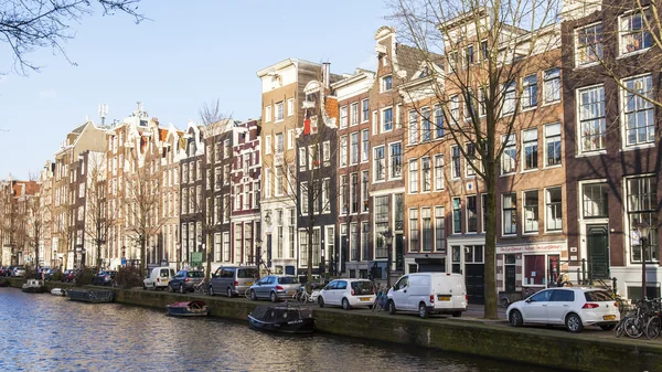 AMSTERDAM, PAÍSES BAJOS 28 DE MARZO DE 2016. Típica vista urbana en la tarde de primavera. El canal y los edificios de la construcción XVII-XVIII sobre terraplenes . — Foto de Stock