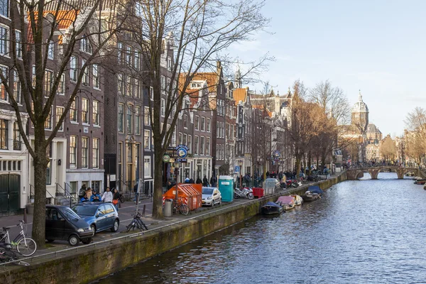Amsterdam, Nizozemsko na 28 březnu 2016. Typický městský pohled jarního odpoledne. Kanál a budovy stavby Xvii a Xviii na nábřežích. — Stock fotografie