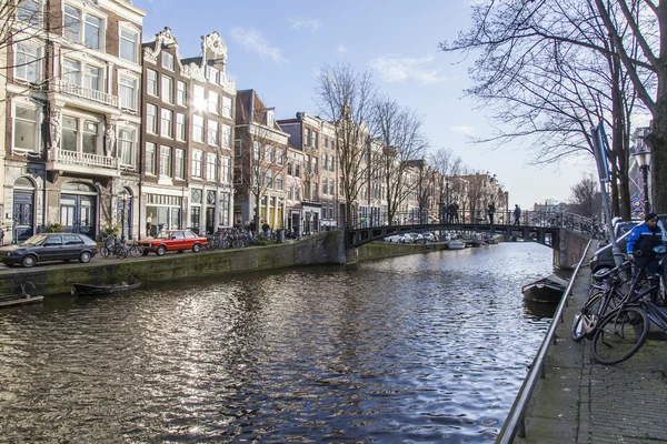 AMSTERDAM, PAÍSES BAJOS 28 DE MARZO DE 2016. Típica vista urbana en la tarde de primavera. El canal y los edificios de la construcción XVII-XVIII sobre terraplenes . — Foto de Stock