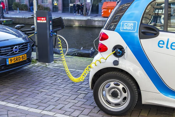 AMSTERDAM, NETHERLANDS on MARCH 29, 2016. The electric car is loaded with energy on the city street — Stock Photo, Image