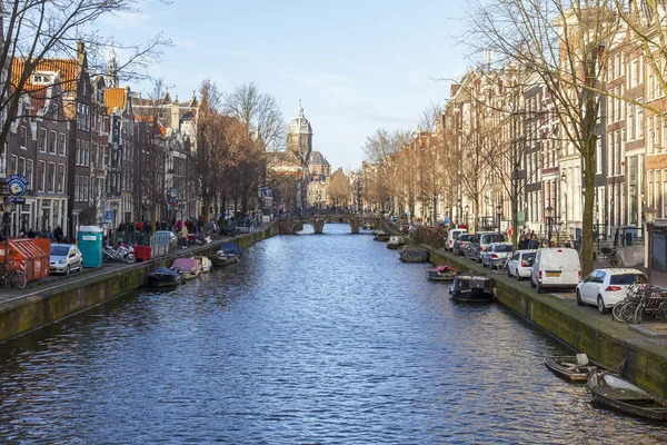 AMSTERDAM, PAÍSES BAJOS 28 DE MARZO DE 2016. Típica vista urbana en la tarde de primavera. El canal y los edificios de la construcción XVII-XVIII sobre terraplenes . —  Fotos de Stock