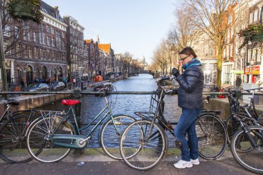 Amsterdam, Hollanda üzerinde 27 Mart 2016. Şehir manzarası. Dondurma şehre karşı köprüde kadınla