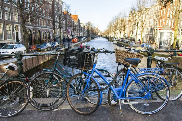 AMESTERDÃO, PAÍSES BAIXOS em 27 de março de 2016. Paisagem urbana. O estacionamento de bicicletas na ponte via canal — Fotografia de Stock