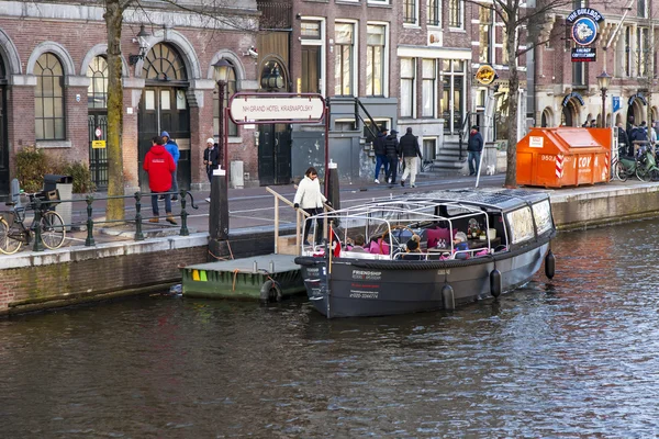 AMSTERDAM, PAESI BASSI il 28 marzo 2016. Tipica vista urbana nel pomeriggio primaverile. Il canale e gli edifici della costruzione XVII-XVIII su argini. La nave che cammina galleggia sul canale — Foto Stock
