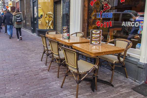 AMSTERDAM, PAÍSES BAJOS 28 DE MARZO DE 2016. Vista típica urbana en primavera. Pequeñas mesas de café de verano bajo el cielo abierto . — Foto de Stock