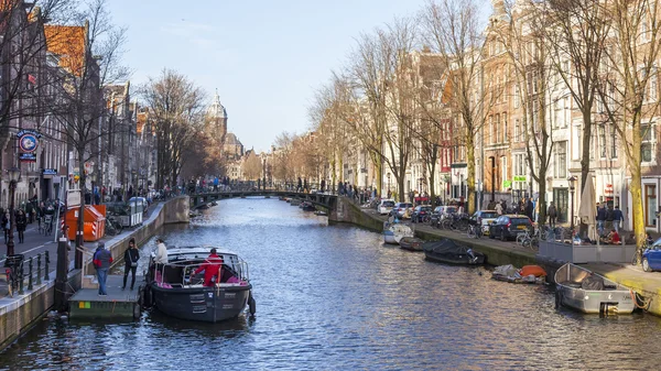 AMSTERDAM, NETHERLANDS on MARCH 28, 2016. Typical urban view in the spring afternoon. The channel and buildings of the XVII-XVIII construction on embankments. — Stock Photo, Image