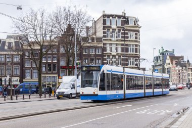 Amsterdam, Hollanda üzerinde 28 Mart 2016. Bahar öğleden sonra tipik kent görünümünde. Tramvay caddeden aşağı taşır. 