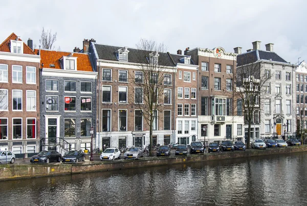 AMSTERDAM, NETHERLANDS on MARCH 28, 2016. River Amstel. Architectural complex of the embankment. Boats are moored at the coast. — Stock Photo, Image