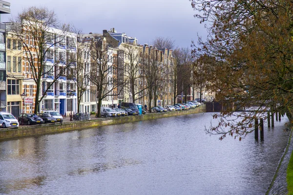 AMSTERDAM, PAÍSES BAJOS 28 DE MARZO DE 2016. Río Amstel. Complejo arquitectónico del terraplén. Barcos amarrados en la costa . — Foto de Stock