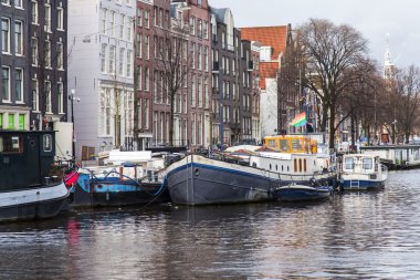 Amsterdam, Hollanda üzerinde 28 Mart 2016. Amstel Nehri. Mimari kompleks set of. Sahilde tekne palamarla.