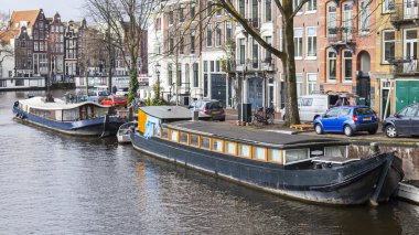 Amsterdam, Hollanda üzerinde 27 Mart 2016. Bahar akşam tipik kent görünümünde. XVII-XVIII inşaat bentleri ve yüzen banka yakınındaki binaların