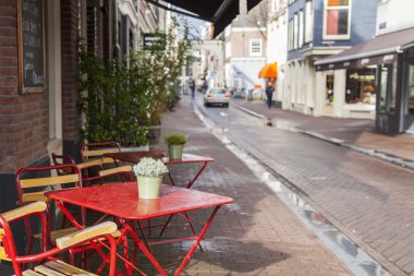 Amsterdam, Hollanda üzerinde 28 Mart 2016. Bahar akşam tipik kent görünümünde. Yaz Kafe'nin kaldırımda küçük tablolar.