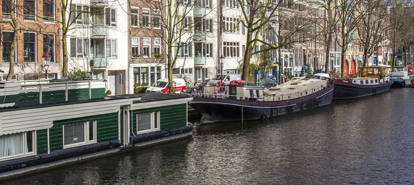Amsterdam, Holandia, 27 mar 2016. Typowy widok w wieczór wiosna. Budynków z Xvii-Xviii budowy nasypów i mieszkalne w pobliżu banku — Zdjęcie stockowe