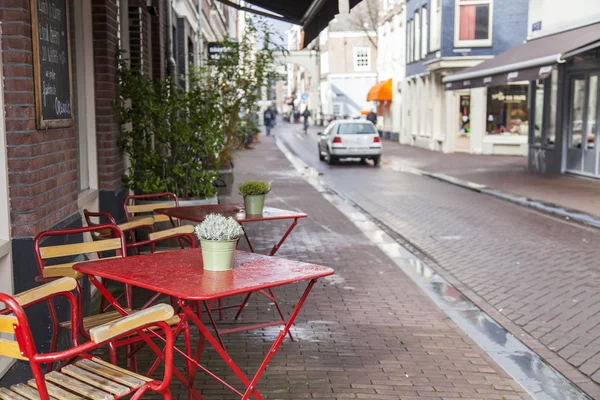 2016 年 3 月 28 日にアムステルダム、オランダ。春の夕べの典型的な都市の風景。歩道の夏カフェの小さなテーブル. — ストック写真