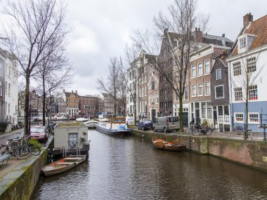 Amsterdam, Hollanda üzerinde 28 Mart 2016. Bahar öğleden sonra tipik kent görünümünde. Kanal ve Binalar bentleri tarihinde XVII-XVIII İnşaat.