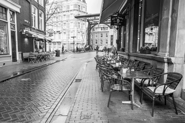 AMSTERDAM, NETHERLANDS on March 28, 2016. Типичный вид на город весной. Маленькие столики летнего кафе на тротуаре . — стоковое фото