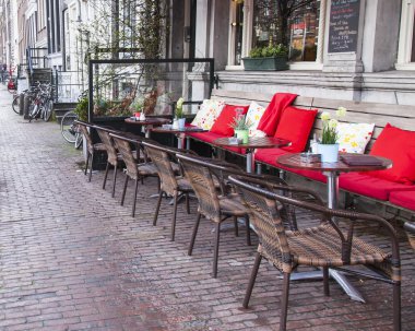 Amsterdam, Hollanda üzerinde 28 Mart 2016. Bahar akşam tipik kent görünümünde. Yaz Kafe'nin kaldırımda küçük tablolar.