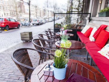 Amsterdam, Hollanda üzerinde 28 Mart 2016. Bahar akşam tipik kent görünümünde. Yaz Kafe'nin kaldırımda küçük tablolar.