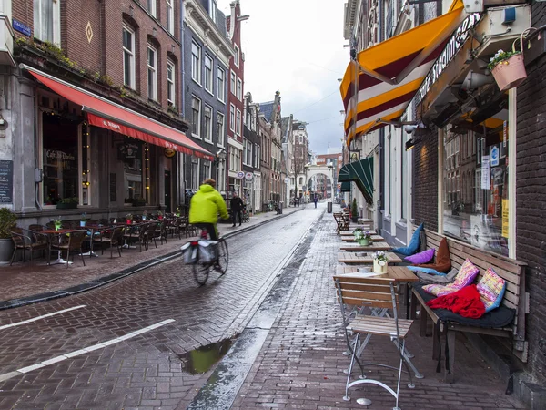 AMSTERDAM, PAYS-BAS, le 28 mars 2016. Vue urbaine typique dans la soirée de printemps. Petites tables de café d'été sur le trottoir . — Photo