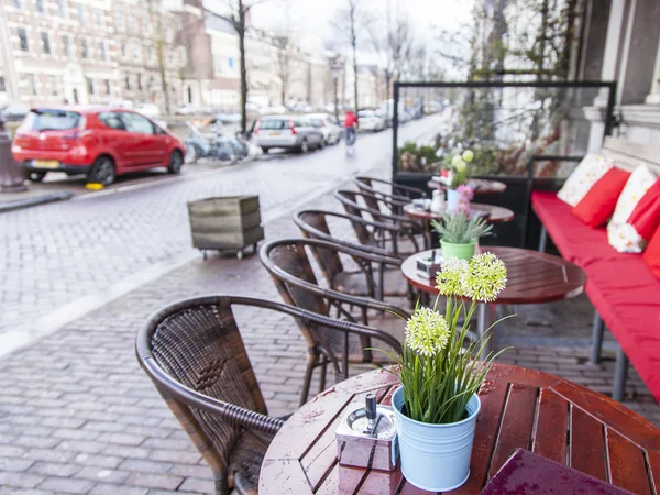 Amszterdam, Hollandia-a március 28, 2016-ban. Tipikus városi Nézd tavaszi este. Nyári kávézó a járdán asztalok. — Stock Fotó