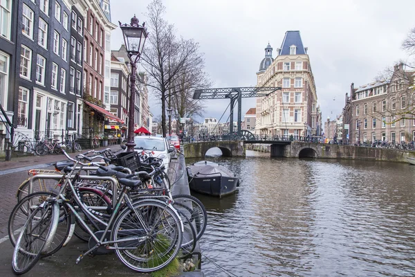 AMSTERDAM, PAYS-BAS, le 28 mars 2016. Vue urbaine typique le matin du printemps. Un vieux pont mobile par le canal au loin — Photo