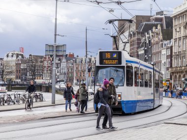 Amsterdam, Hollanda üzerinde 27 Mart 2016. Bahar akşam tipik kent görünümünde. Tramvay caddeden aşağı taşır