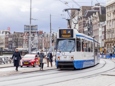 Amsterdam, Hollanda üzerinde 27 Mart 2016. Bahar akşam tipik kent görünümünde. Tramvay caddeden aşağı taşır