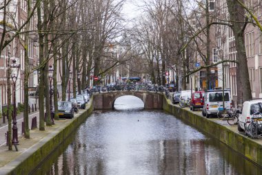 Amsterdam, Hollanda üzerinde 27 Mart 2016. Bahar akşam tipik kent görünümünde. Kanal ve Binalar bentleri tarihinde XVII-XVIII inşaatın Köprüsü